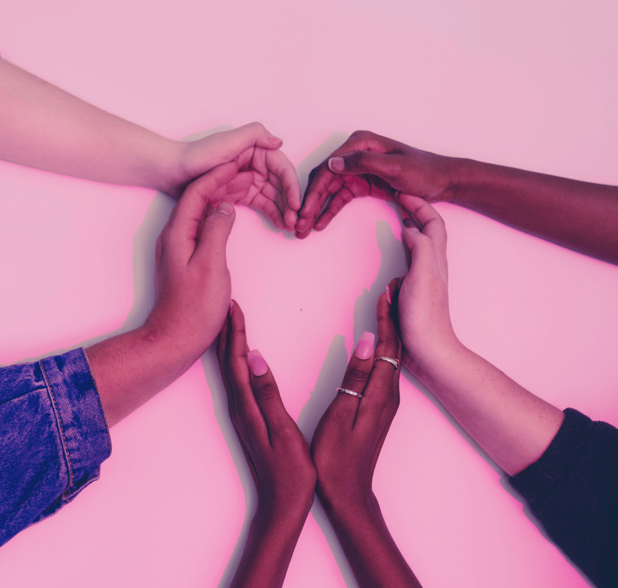 5 mains en forme de cœur sous une lumière rose